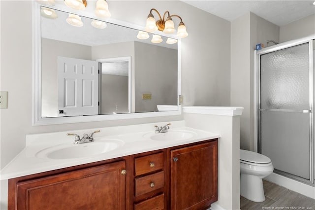 bathroom featuring hardwood / wood-style floors, vanity, toilet, and a shower with shower door