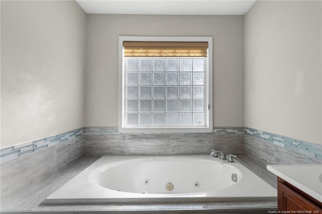 bathroom featuring vanity and tiled bath