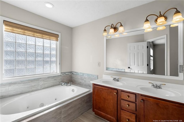 bathroom with vanity and a relaxing tiled tub