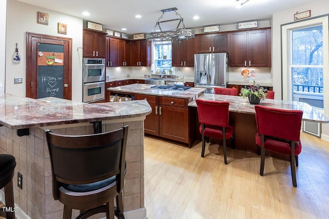 kitchen with a center island, stainless steel appliances, and a breakfast bar area