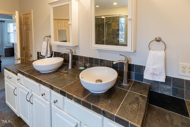 bathroom with vanity and tiled shower