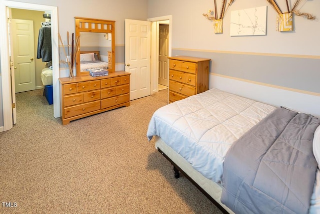 bedroom with carpet, a walk in closet, and a closet