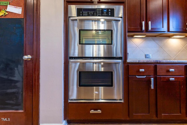 kitchen featuring double oven and tasteful backsplash