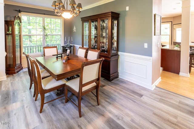 5240 Indigo Moon Way, Raleigh, NC 27613 - dining room featuring light wood-type flooring, a wainscoted wall, a chandelier, and crown molding