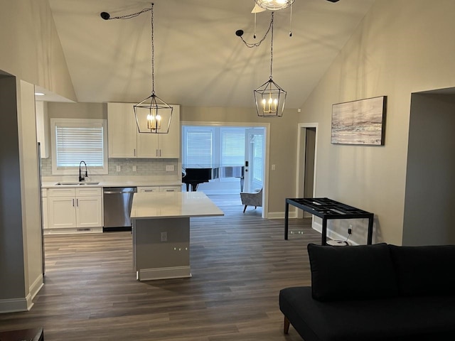 kitchen with white cabinets, backsplash, hanging light fixtures, and sink