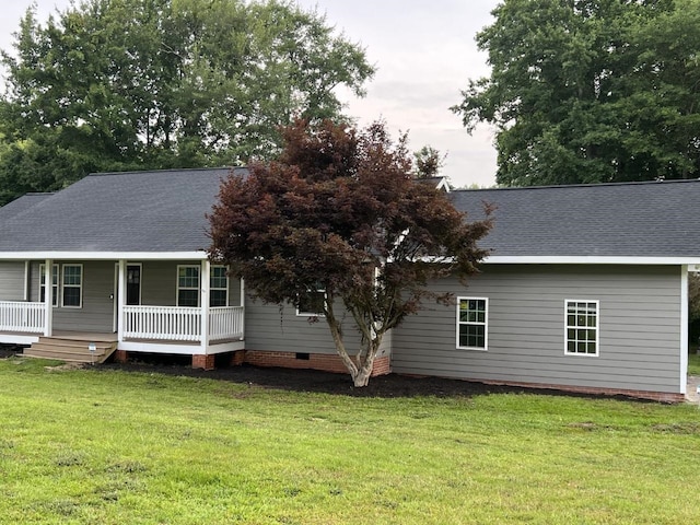 back of house with a lawn and covered porch