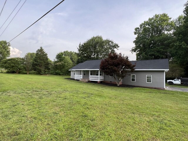 exterior space featuring covered porch and a front yard