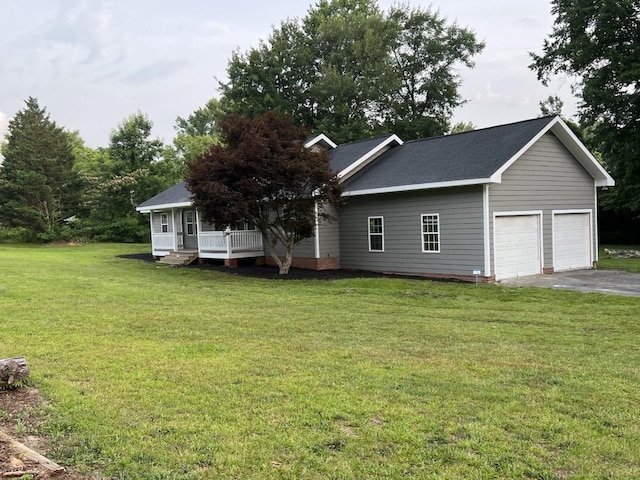 view of front of house featuring covered porch, a garage, and a front lawn