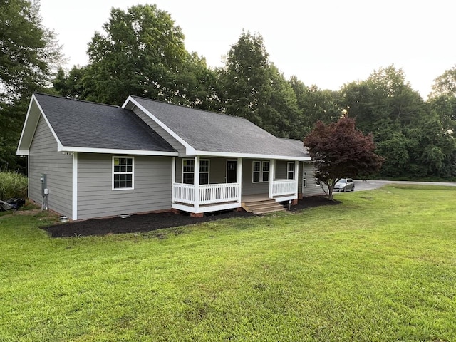 rear view of house with a lawn and covered porch