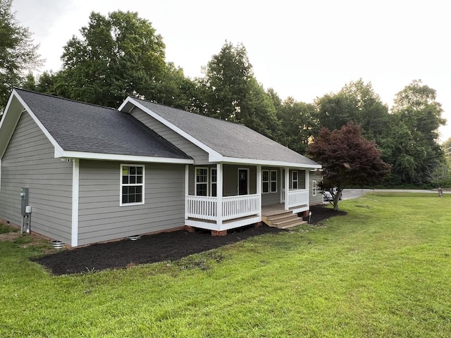 rear view of house featuring a lawn and covered porch