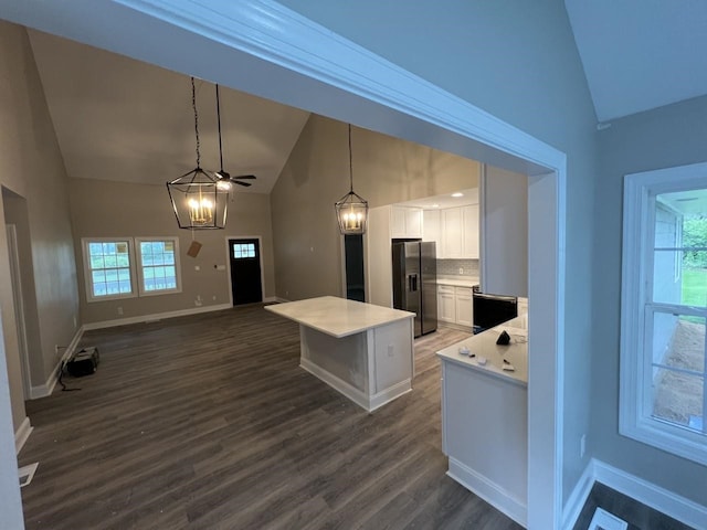 kitchen with stainless steel fridge, tasteful backsplash, ceiling fan, pendant lighting, and white cabinetry