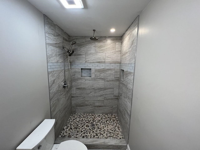 bathroom with toilet and tiled shower