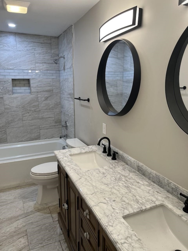 full bathroom featuring vanity, toilet, and tiled shower / bath