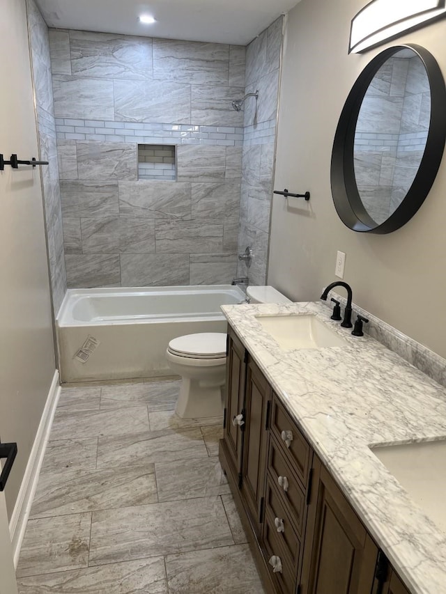 full bathroom featuring tiled shower / bath combo, toilet, and vanity