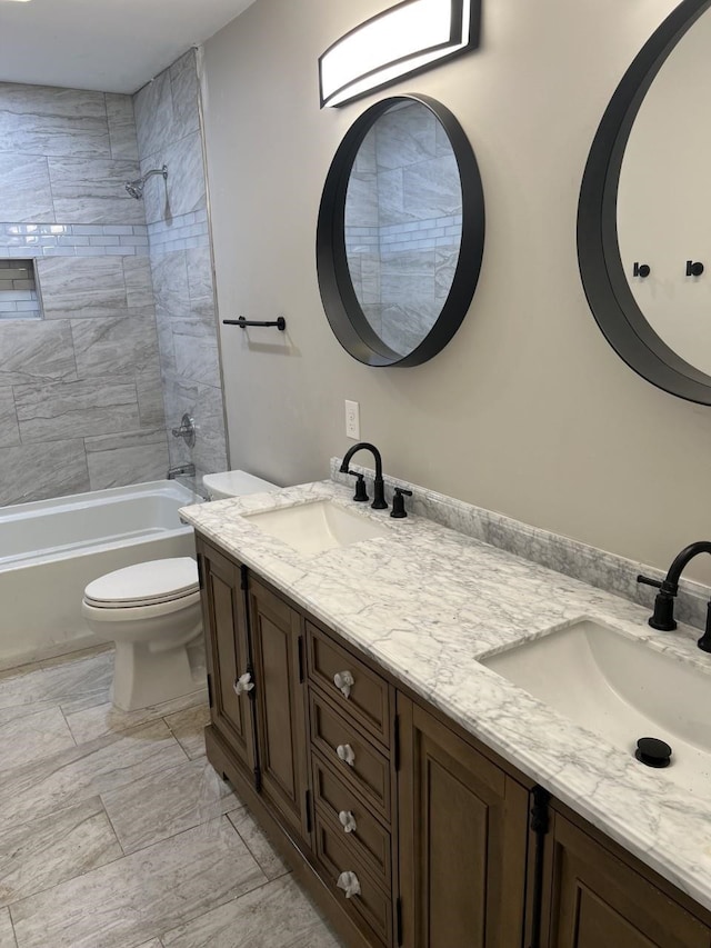 full bathroom featuring vanity, tiled shower / bath combo, and toilet