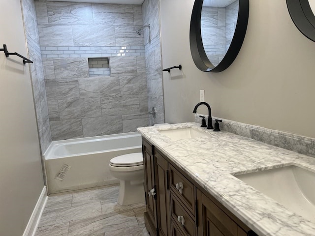 full bathroom featuring tiled shower / bath, vanity, and toilet