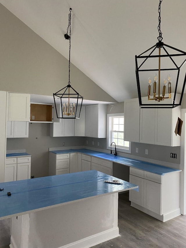 kitchen with pendant lighting, a center island, white cabinets, and a chandelier