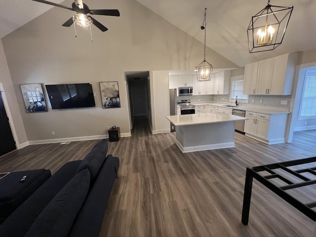 kitchen with a center island, stainless steel appliances, tasteful backsplash, pendant lighting, and white cabinets