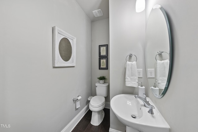 bathroom with toilet, hardwood / wood-style floors, and sink