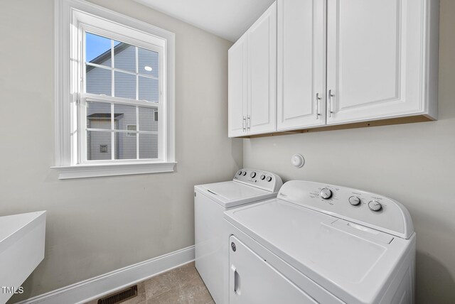 washroom with light tile patterned flooring, cabinets, and separate washer and dryer