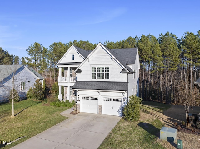 view of front of house featuring a balcony, a garage, and a front lawn