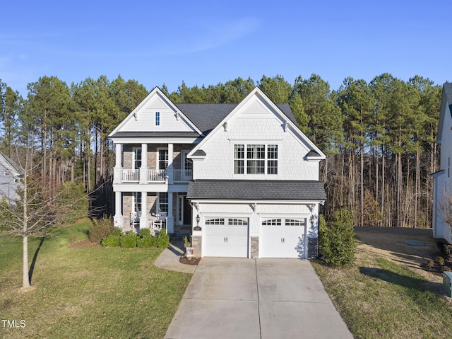 view of front of home featuring covered porch, a balcony, a front lawn, and a garage