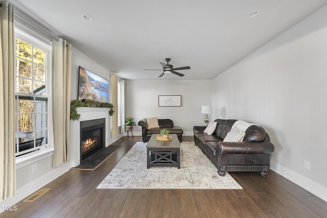 living room featuring ceiling fan and dark hardwood / wood-style floors