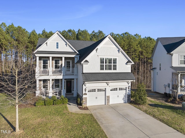 view of front of home featuring a balcony, a front lawn, and a garage