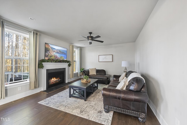 living room with dark wood-type flooring and ceiling fan