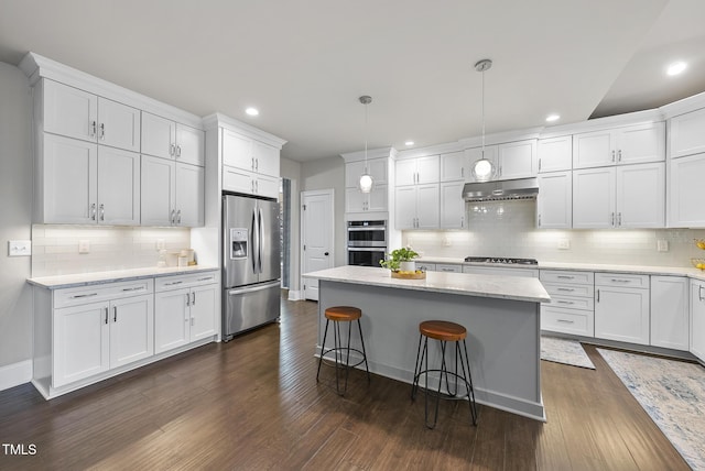 kitchen with stainless steel appliances, pendant lighting, and white cabinetry