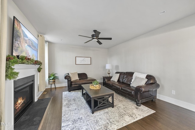 living room featuring dark wood-type flooring and ceiling fan