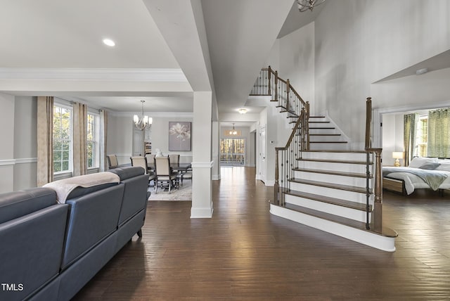 living room featuring dark hardwood / wood-style flooring, ornamental molding, and a chandelier