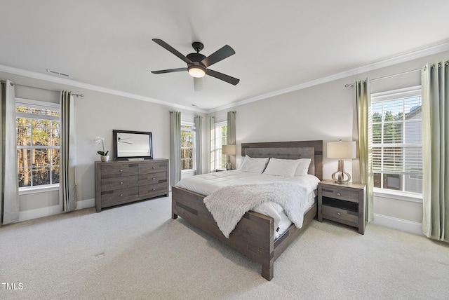 carpeted bedroom with multiple windows, ceiling fan, and crown molding