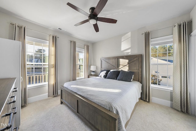 carpeted bedroom with multiple windows and ceiling fan