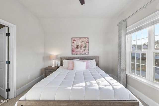 carpeted bedroom with ceiling fan and vaulted ceiling