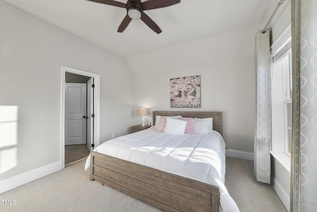 bedroom with ceiling fan, light colored carpet, and vaulted ceiling