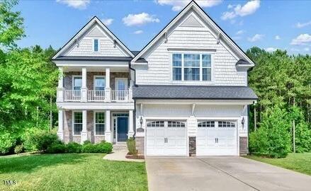 view of front of house featuring a front yard, a balcony, and a garage