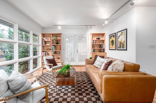 living room with hardwood / wood-style flooring, track lighting, and built in features