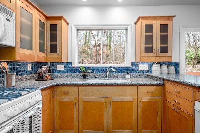 kitchen featuring tasteful backsplash, sink, white appliances, and light stone countertops