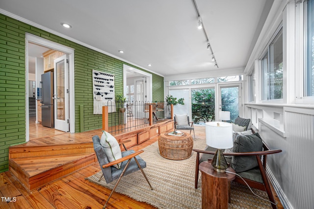 sunroom / solarium featuring rail lighting