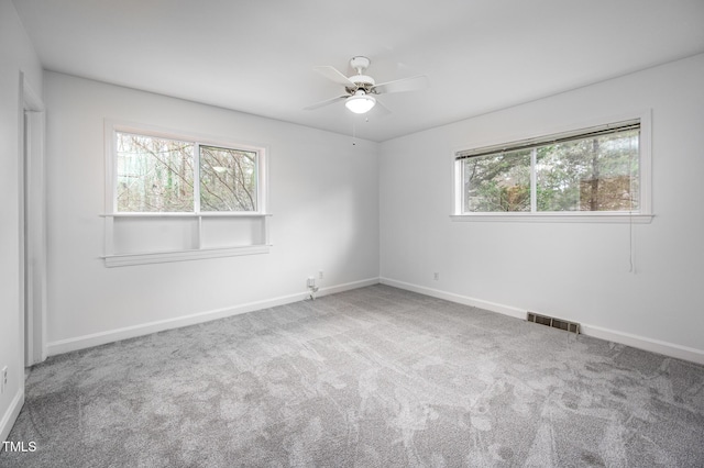 unfurnished room with ceiling fan and carpet