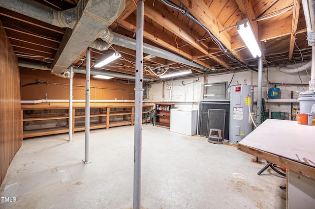 basement featuring electric water heater, refrigerator, and a workshop area