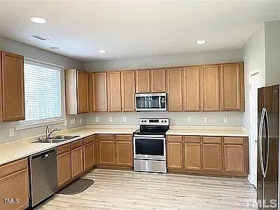 kitchen featuring sink, light hardwood / wood-style flooring, and appliances with stainless steel finishes