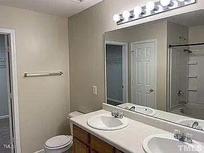 full bathroom with bathtub / shower combination, vanity, and toilet