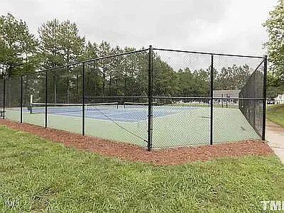 view of tennis court with a yard