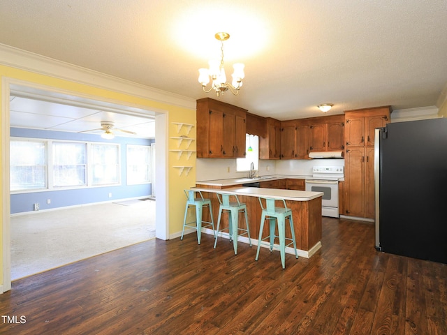 kitchen with kitchen peninsula, stainless steel fridge, ceiling fan with notable chandelier, pendant lighting, and white electric range