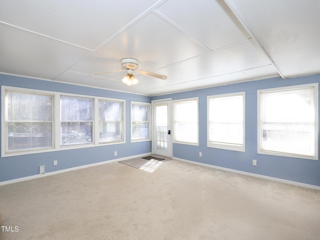 empty room featuring plenty of natural light, ceiling fan, and light carpet