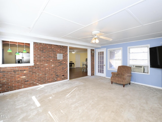 unfurnished room with ceiling fan, carpet floors, cooling unit, and brick wall