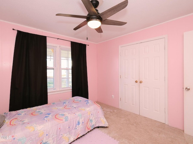 bedroom featuring ceiling fan, a closet, carpet, and crown molding