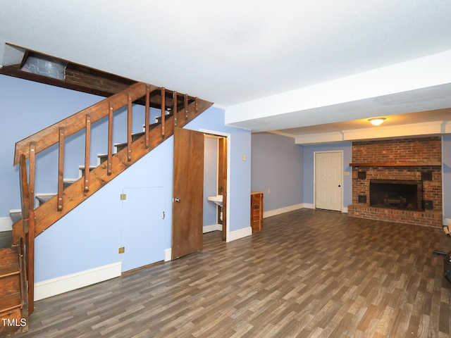 unfurnished living room featuring dark hardwood / wood-style floors and a brick fireplace